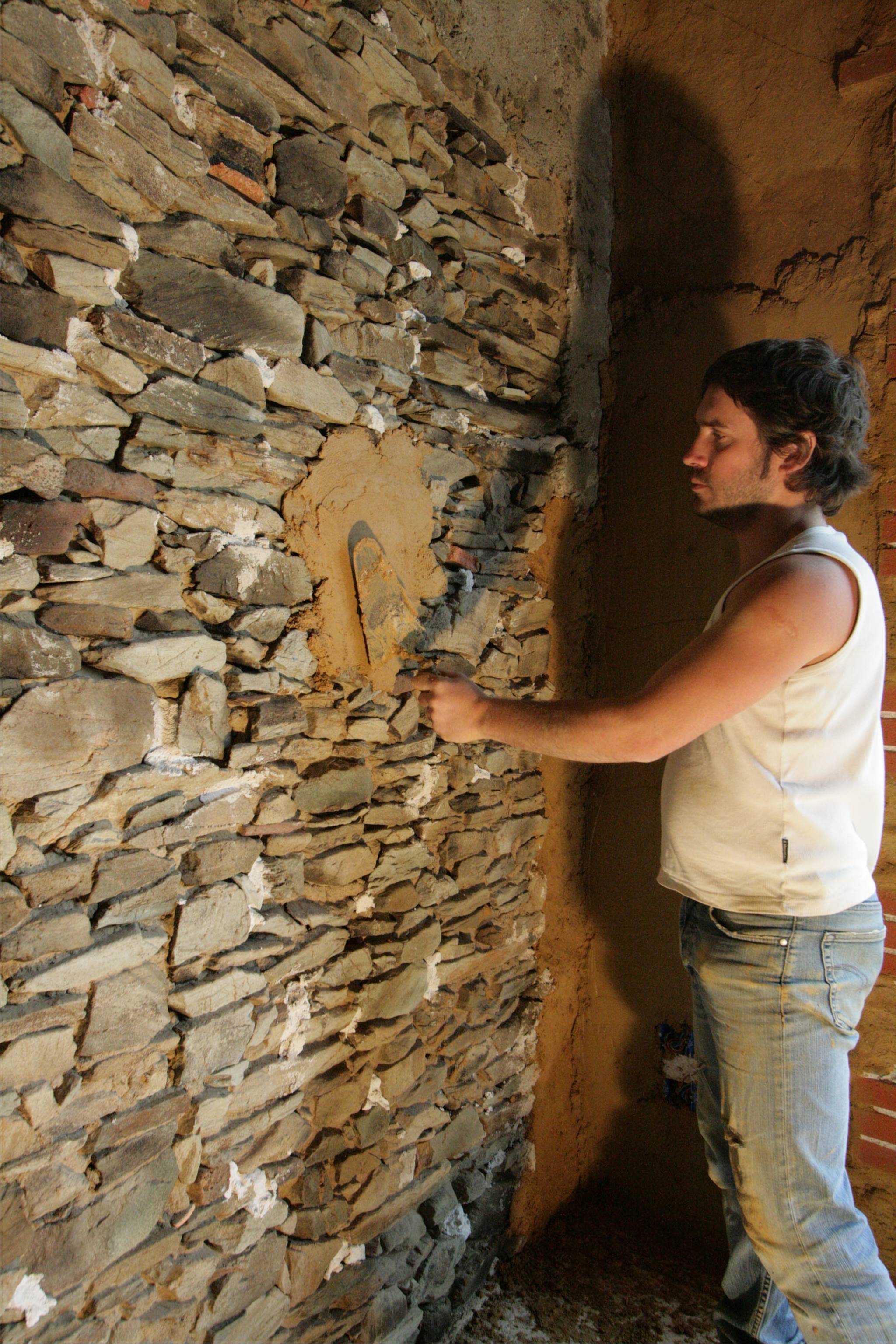 Application du torchis sur mur en pierre - Argilus